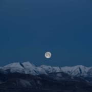 Vollmond über den schneebedeckten Bergen