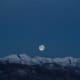 Vollmond über den schneebedeckten Bergen